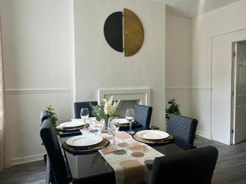 a dining room with a table with plates and chairs at Crystal House- Liverpool City in Litherland