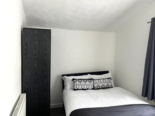 a bedroom with a bed with a black cabinet at Crystal House- Liverpool City in Litherland