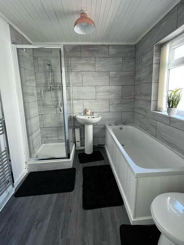 a bathroom with a tub and a sink at Crystal House- Liverpool City in Litherland