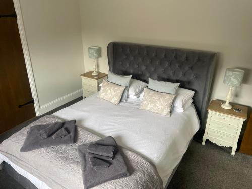 a bedroom with a large bed with towels on it at The Stables in Hereford