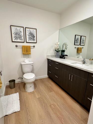 a bathroom with a toilet and a sink and a mirror at Nimitz Crossing Luxury Residences in San Diego