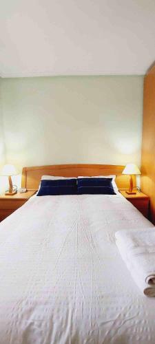 1 cama blanca grande en un dormitorio con 2 lámparas en HABITACIÓN EN BILBAO, en Bilbao