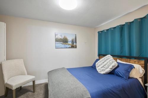 1 dormitorio con cortina azul, 1 cama y 1 silla en Snohomish 1 Bed Apt - In Town Great, Central Loc, en Snohomish