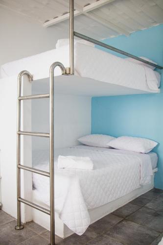 a bedroom with two bunk beds with white sheets at Pacífico Cielo Eco Hotel in Atitancito