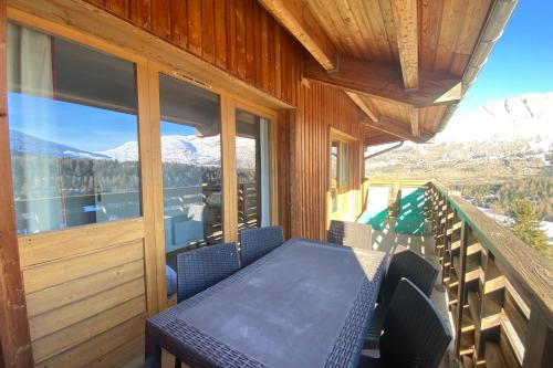 un porche avec une table et des chaises sur un balcon dans l'établissement Apartment with balcony and superb view, à Saint-Étienne-en-Dévoluy