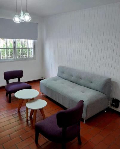 a living room with a couch and two tables and chairs at Tu casita de paso 2 in General Acha