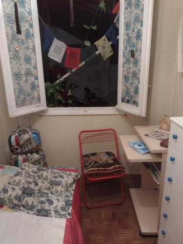 um pequeno quarto com uma cama, uma secretária e uma janela em Habitación acogedora por días em Madri
