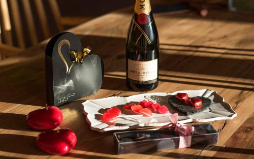 een fles wijn en een doos kersen en een fles prosecc bij Suites Niditas in Yuso