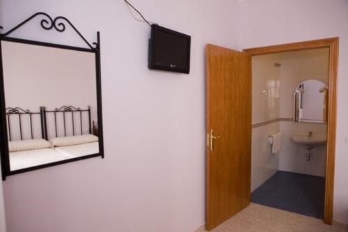 um quarto com um espelho e uma casa de banho com um lavatório em Hotel Don Juan em El Coronil