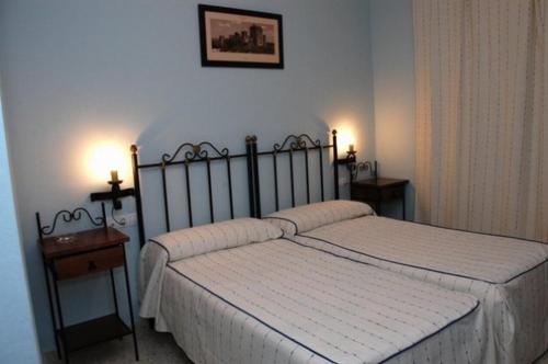 um quarto com uma cama e duas mesas de cabeceira em Hotel Don Juan em El Coronil