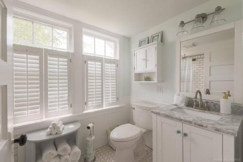 La salle de bains blanche est pourvue de toilettes et d'un lavabo. dans l'établissement Waterfront Cottages in Lexington Vacation Homes, à Lexington