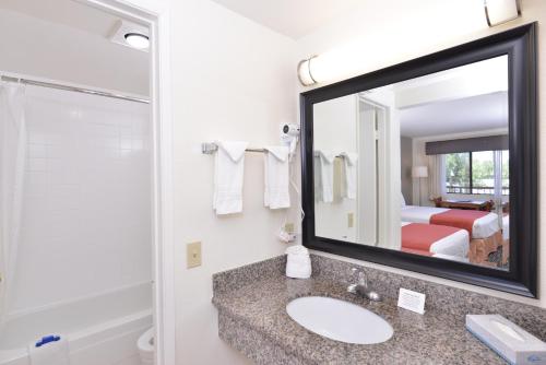 a bathroom with a sink, mirror, and toilet at Pleasant Inn in San Diego