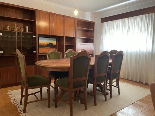 a dining room with a wooden table and chairs at Sand Guest House Torreira in Torreira