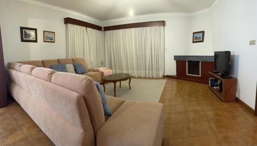 a living room with a couch and a tv at Sand Guest House Torreira in Torreira