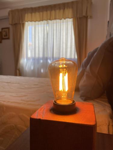 a glass lamp on a table in a bedroom at Sand Guest House Torreira in Torreira