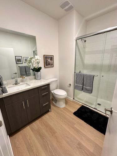 a bathroom with a shower and a toilet and a sink at Nimitz Crossing Luxury Residences in San Diego