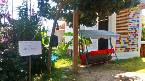 a table and a chair in a garden with a sign at Baliyesan in Ica