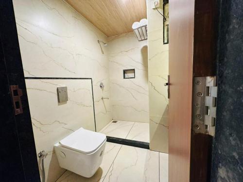 a bathroom with a toilet and a walk in shower at Aananda Wellness and Resorts in Dharmastala