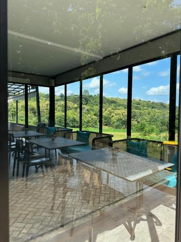 a large room with tables and chairs and windows at Svarna Padi in Grigak