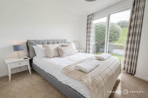 a bedroom with a large bed with a window at Shoreline Suite by Grandeur Property in Southbourne