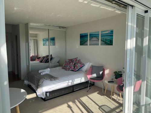 a bedroom with a bed and a table and chairs at Dee Why Beach - Studio 29 Surfrider in Deewhy