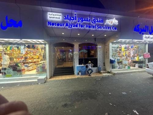 a store with a person sitting in front of it at فندق النسور اجياد in Ajyad