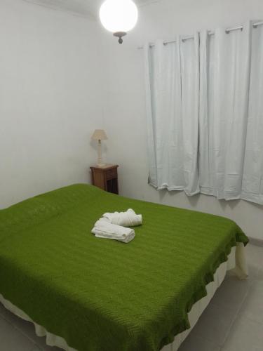 un letto verde con due asciugamani sopra di Casa da paz a Miguel Pereira
