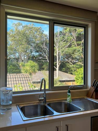 a kitchen sink in front of a window at Luxurious Comfort with Bay Views in Frankston South
