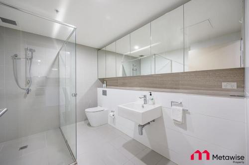 La salle de bains est pourvue de toilettes, d'un lavabo et d'une douche. dans l'établissement MetaWise Burwood Westfield Cozy 2Bed Free Parking VT108, à Sydney