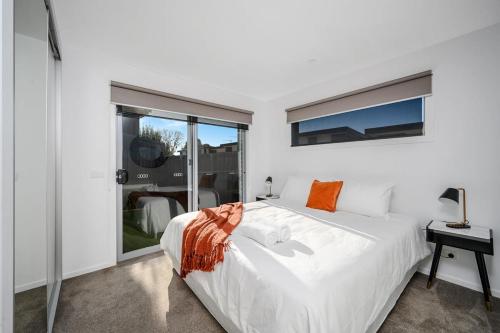 Habitación blanca con cama y ventana en The Bay Abode Modern New 2 bedroom 15min to CBD, en Kingston Beach