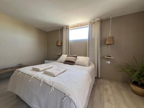 a bedroom with a large bed with towels on it at Casa Andes in San Pedro de Atacama