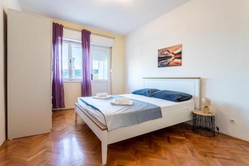ein Schlafzimmer mit einem Bett und einem großen Fenster in der Unterkunft Apartments with a parking space Vinisce, Trogir - 1165 in Vinišće