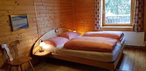 um quarto com uma cama numa parede de madeira em Urlaub bei Freunden, sonnige Seite der Turracher Höhe em Brandstätter