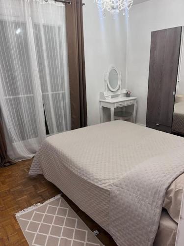 um quarto com uma cama, uma mesa e um espelho em Très bel appart à 2mns du Metro et du Canal/Parc em Pantin