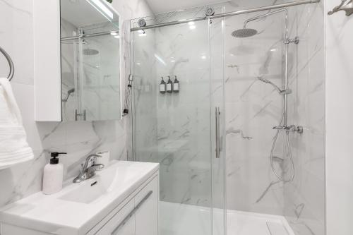 uma casa de banho branca com um chuveiro e um lavatório. em Montreal's most incredible apart em Montreal