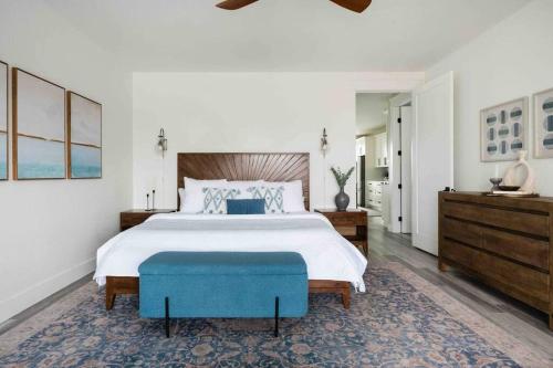 1 dormitorio con 1 cama grande y 1 reposapiés azul en Luxury Lake LBJ Waterfront Home with Hot Tub and Boat Slip, en Kingsland