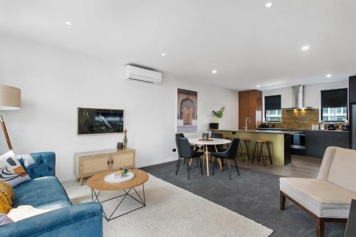a living room with a blue couch and a table at Simply The Best CBD 3 Mins Plus Garage in Christchurch
