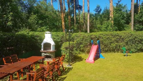 a playground with a picnic table and a slide at Dom Wakacyjny in Rowy