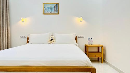 una cama con un osito de peluche sentado encima en Princess Palace Larvotto Beach Monte-Carlo en Montecarlo