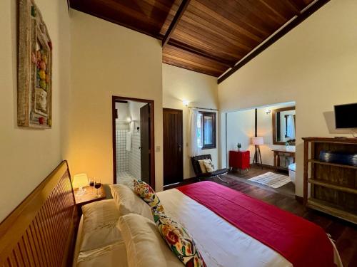 a bedroom with a large bed and a couch at Pousada Chalés Jardim das Bromélias - Visconde de Mauá in Visconde De Maua
