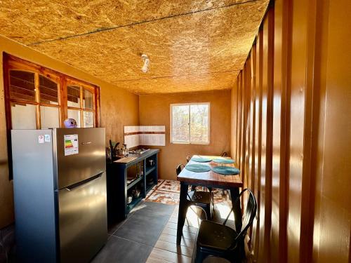una pequeña cocina con mesa y nevera en casa turis en San Pedro de Atacama