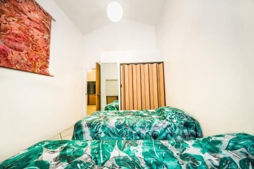 a bedroom with two beds and a painting on the wall at Are Kapakapa in Arutanga