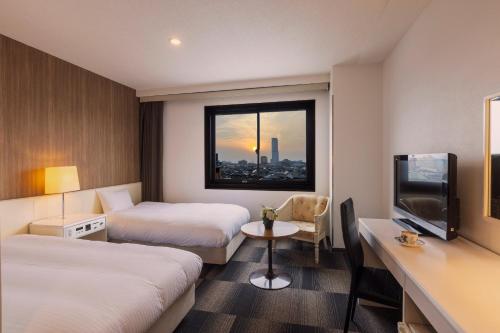 a hotel room with two beds and a television at City Hotel Air Port in Prince in Izumi-Sano