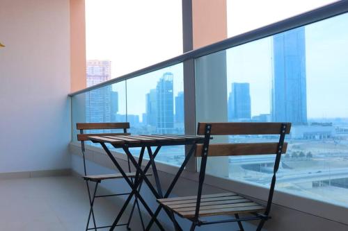 a balcony with a table and two chairs on it at Al Reem Cozy 1BR Apartment - Comfortable Stay Near Reem Mall & Al Maryah Island in Abu Dhabi