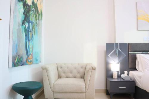 a living room with a chair and a bed at Al Reem Cozy 1BR Apartment - Comfortable Stay Near Reem Mall & Al Maryah Island in Abu Dhabi