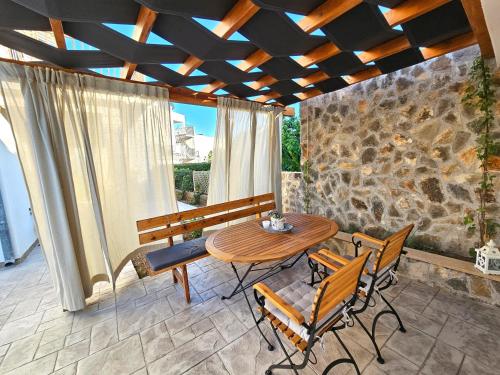 a table and chairs on a patio with a stone wall at Apartments by the sea Rogoznica - 22448 in Rogoznica