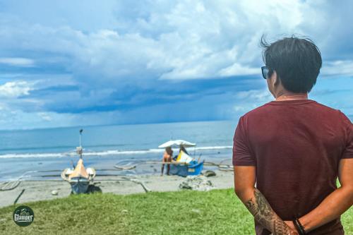 a man standing on the beach looking at the ocean at Glamper Grove- Real, Quezon in Tignuan