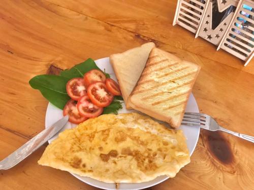 un plato de comida con huevos, tostadas y tomates en Sapa indigo inn, en Sa Pa