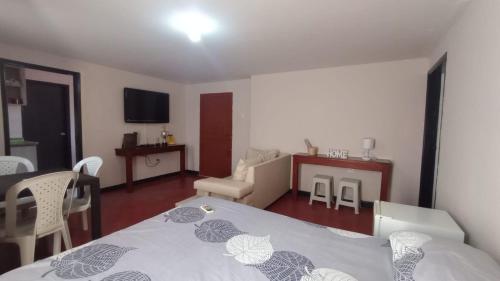 een slaapkamer met een bed en een woonkamer bij Apartamentos Flowers House in Valledupar