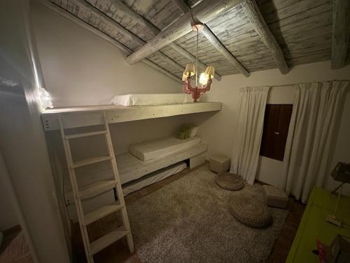 a room with a bunk bed with a ladder at NuriahBoutique in Boliqueime